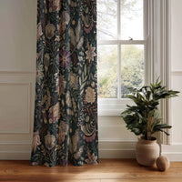 Black moody floral curtain panel hanging by a white window