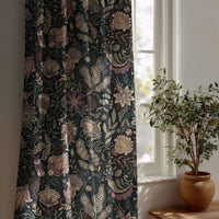 Black moody floral curtain beside a potted olive tree