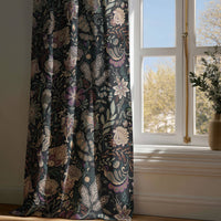 Full-length black moody floral curtain draping to a wooden floor