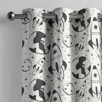 Black and white space rocket kids curtain on a grommet rod, close-up of the print