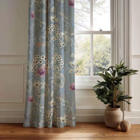 Blue floral curtain panel with dandelion wildflower print hanging by a white window