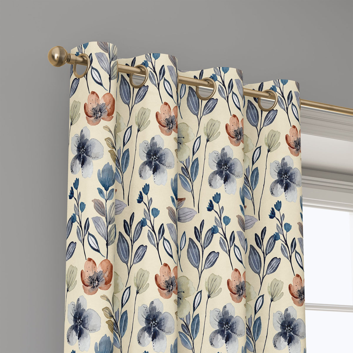 Grommet top of a blue folk wildflower curtain on a brass rod