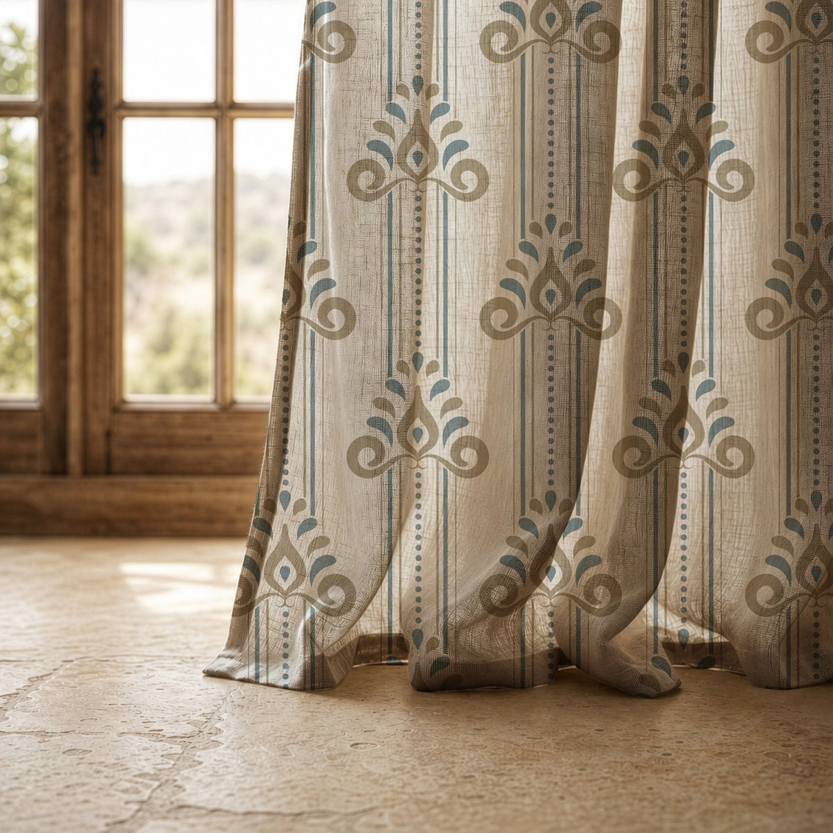 Hem of a blue and gold ornamental stripe curtain resting on a stone floor