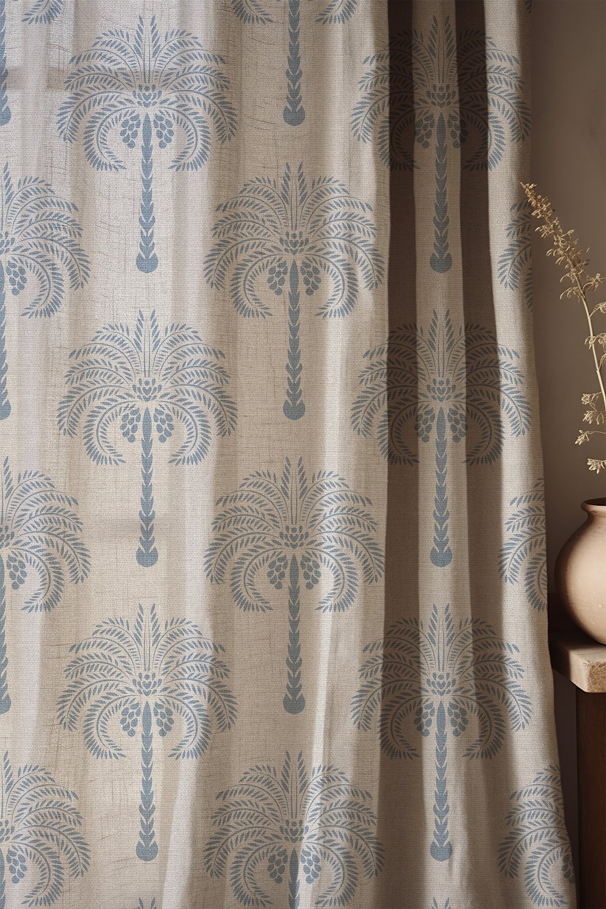 Soft folds of a blue palm tree curtain