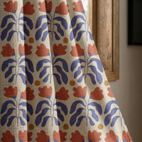 Blue and red cut out leaf curtain panel beside a rustic wooden window