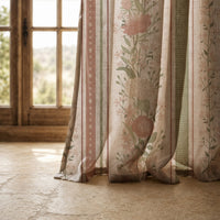 Hem of a blush floral trellis stripe curtain resting on a stone floor