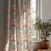 Boho rainbow nursery curtain beside a potted olive tree