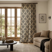 Charcoal rabbit toile curtain on a black rod by a window