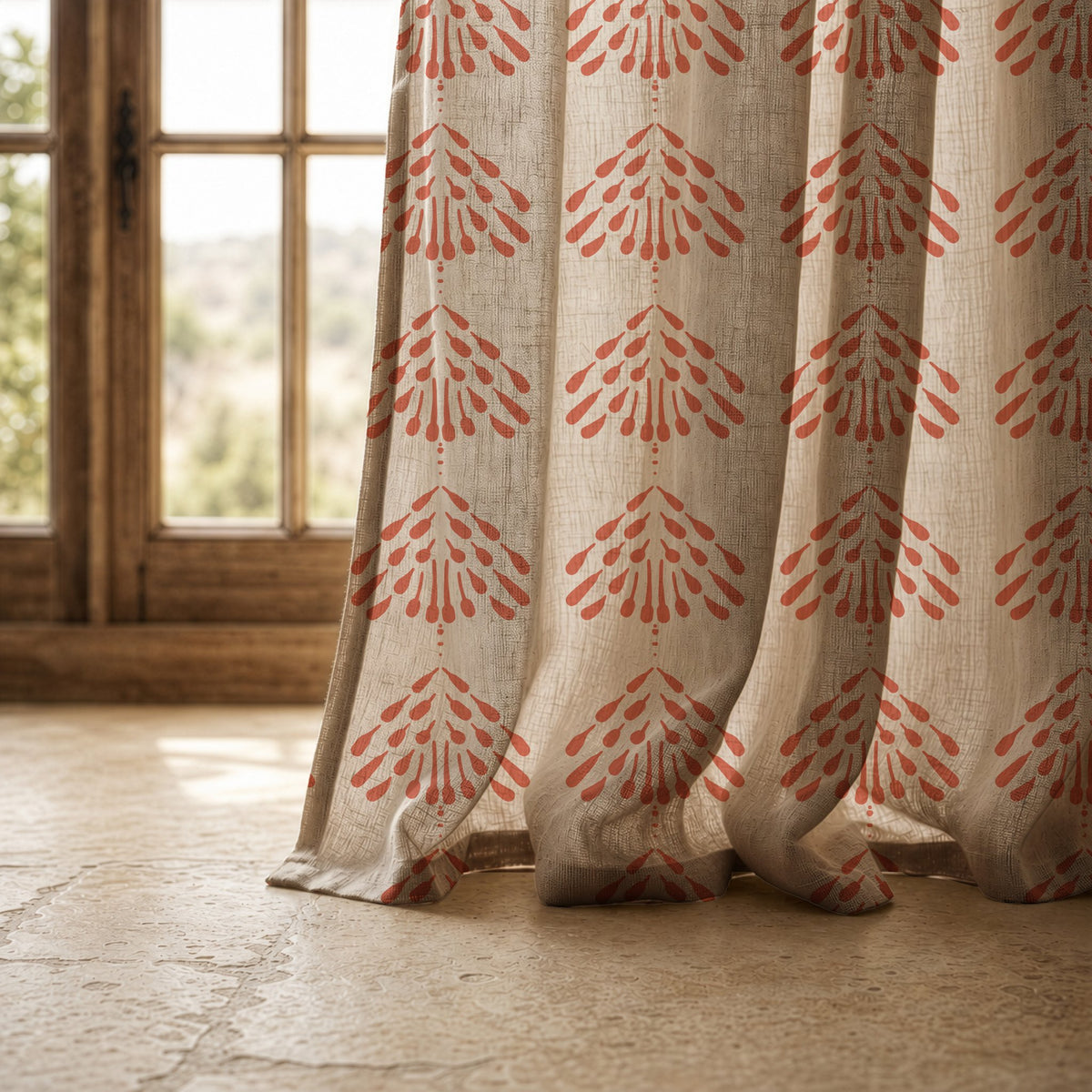 Hem of a coral palmette block print curtain resting on a stone floor