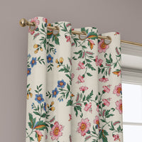 Grommet top of a cottage ditsy floral curtain on a brass rod