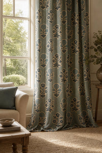 Duck egg blue block print curtain on a black rod by a window