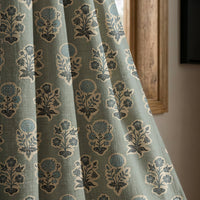 Duck egg blue block print curtain panel beside a rustic wooden window