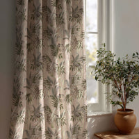 Green fern botanical curtain beside a potted olive tree