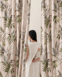 Woman standing between two green fern botanical curtain panels