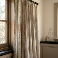 Green and rust painted stripe curtains in a warm living room