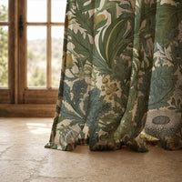 Hem of a green thistle botanical curtain resting on a stone floor