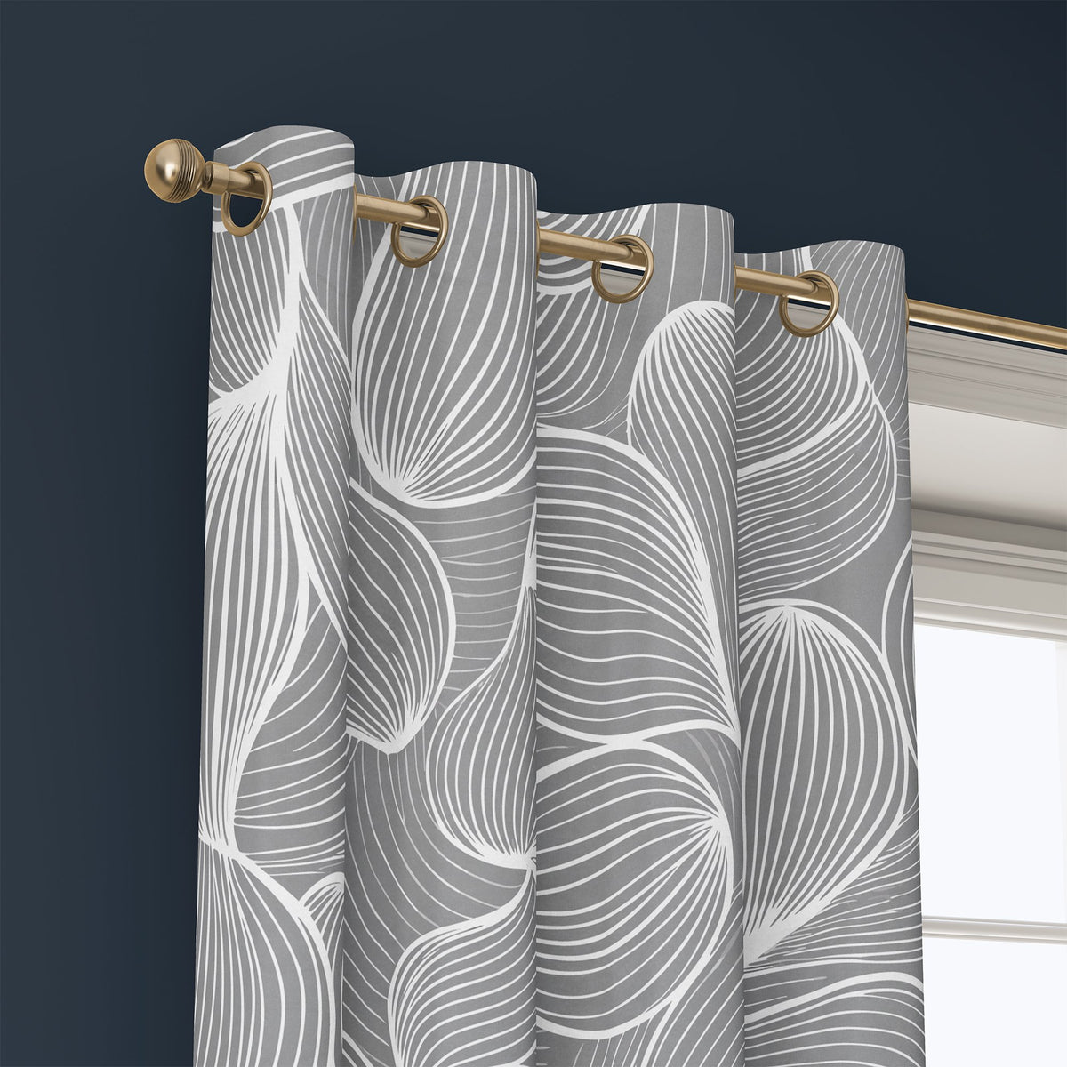 Grommet top of a grey line art leaf curtain on a brass rod