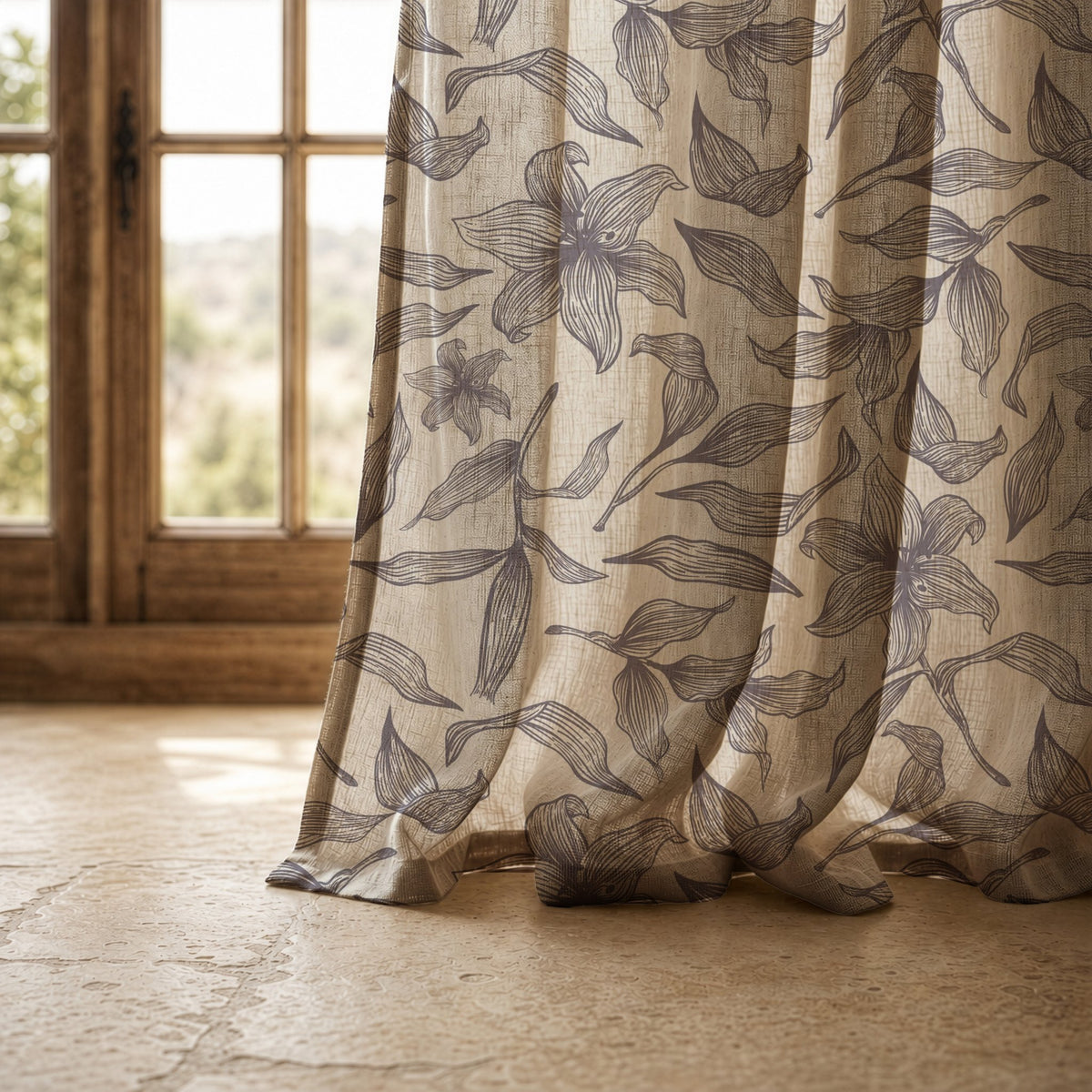 Hem of a grey line art lily curtain resting on a stone floor