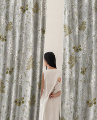 Woman standing between two grey sage botanical floral curtain panels