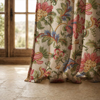 Hem of a jacobean floral curtain resting on a stone floor