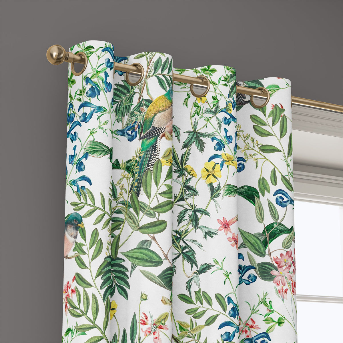 Grommet top of a jungle botanical floral curtain on a brass rod