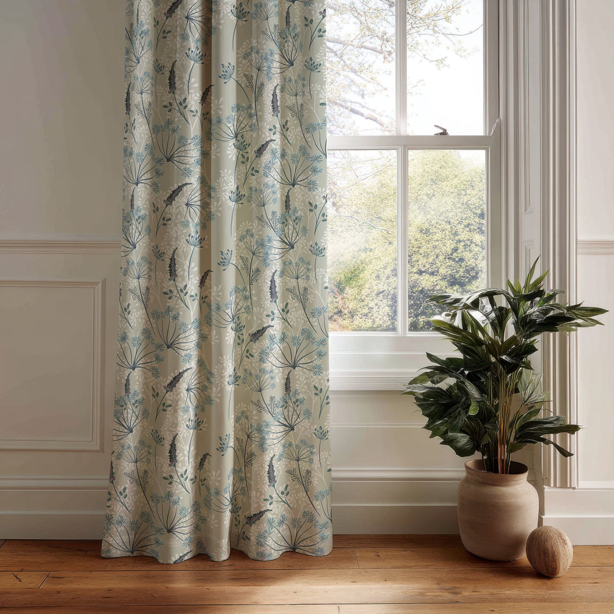 Light blue meadow flower curtain panel hanging by a white window