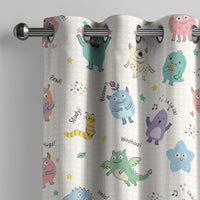 Little monsters kids curtain on a grommet rod, close-up of the print