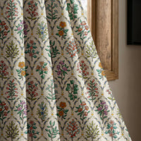 Mughal flower block print curtain panel beside a rustic wooden window
