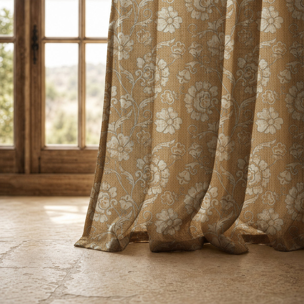 Hem of a mustard floral damask curtain resting on a stone floor