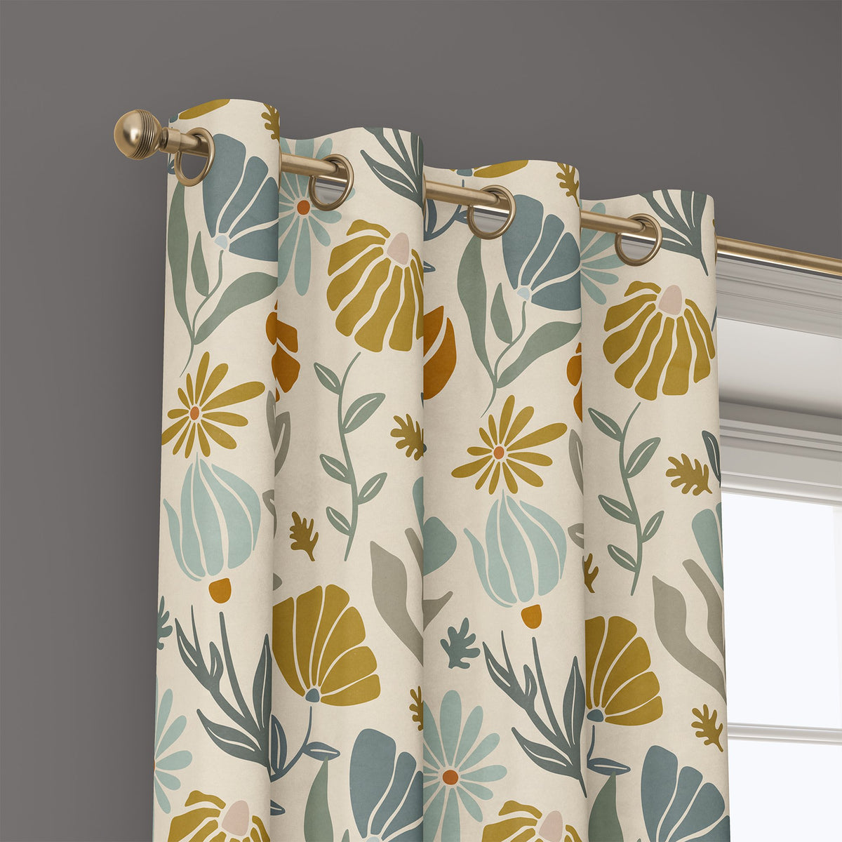 Grommet top of a mustard and sage boho botanical curtain on a brass rod