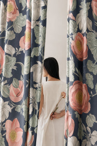 Woman standing between two navy large peony floral curtain panels