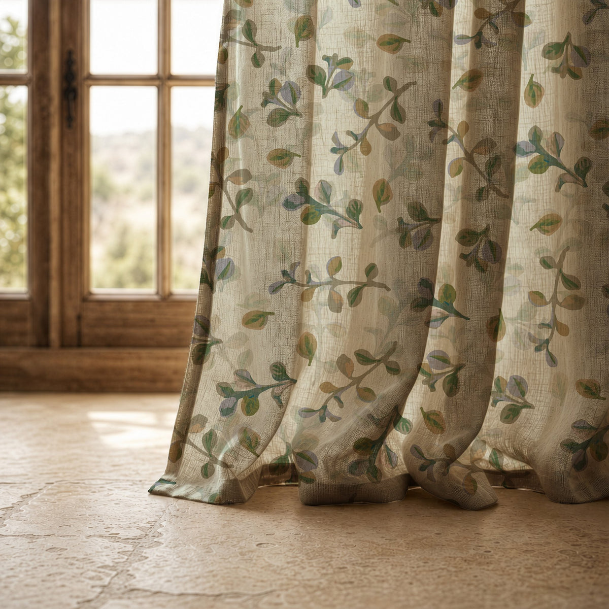 Hem of a olive leaf sprig curtain resting on a stone floor