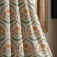 Orange ogee floral curtain panel beside a rustic wooden window