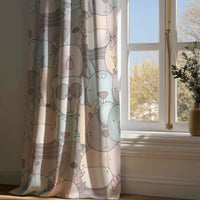 Full-length pastel animal nursery curtain draping to a wooden floor