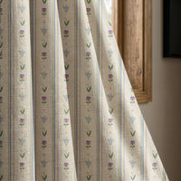 Pastel ditsy floral stripe curtain panel beside a rustic wooden window