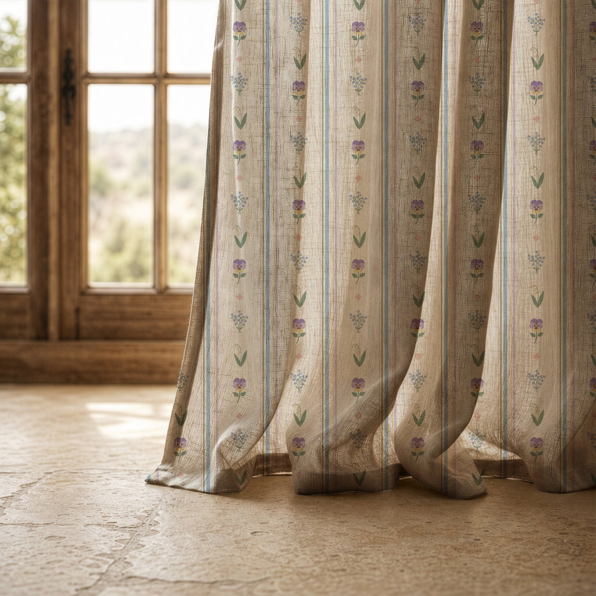 Hem of a pastel ditsy floral stripe curtain resting on a stone floor