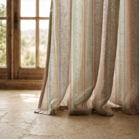 Hem of a pastel stripe curtain resting on a stone floor