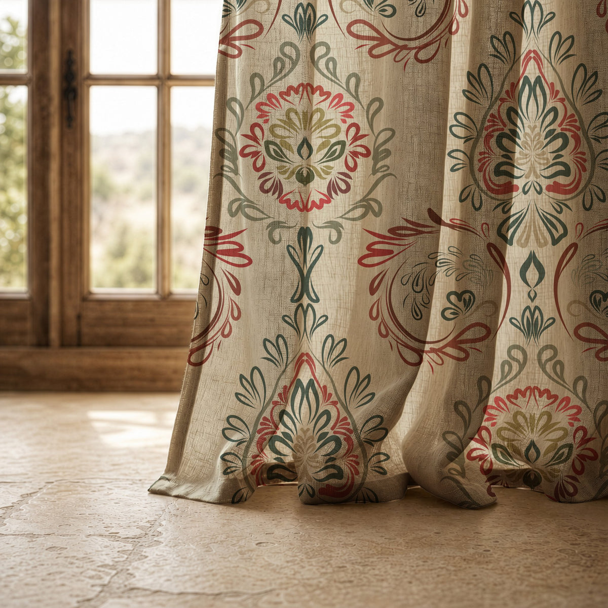 Hem of a red and green folk damask curtain resting on a stone floor