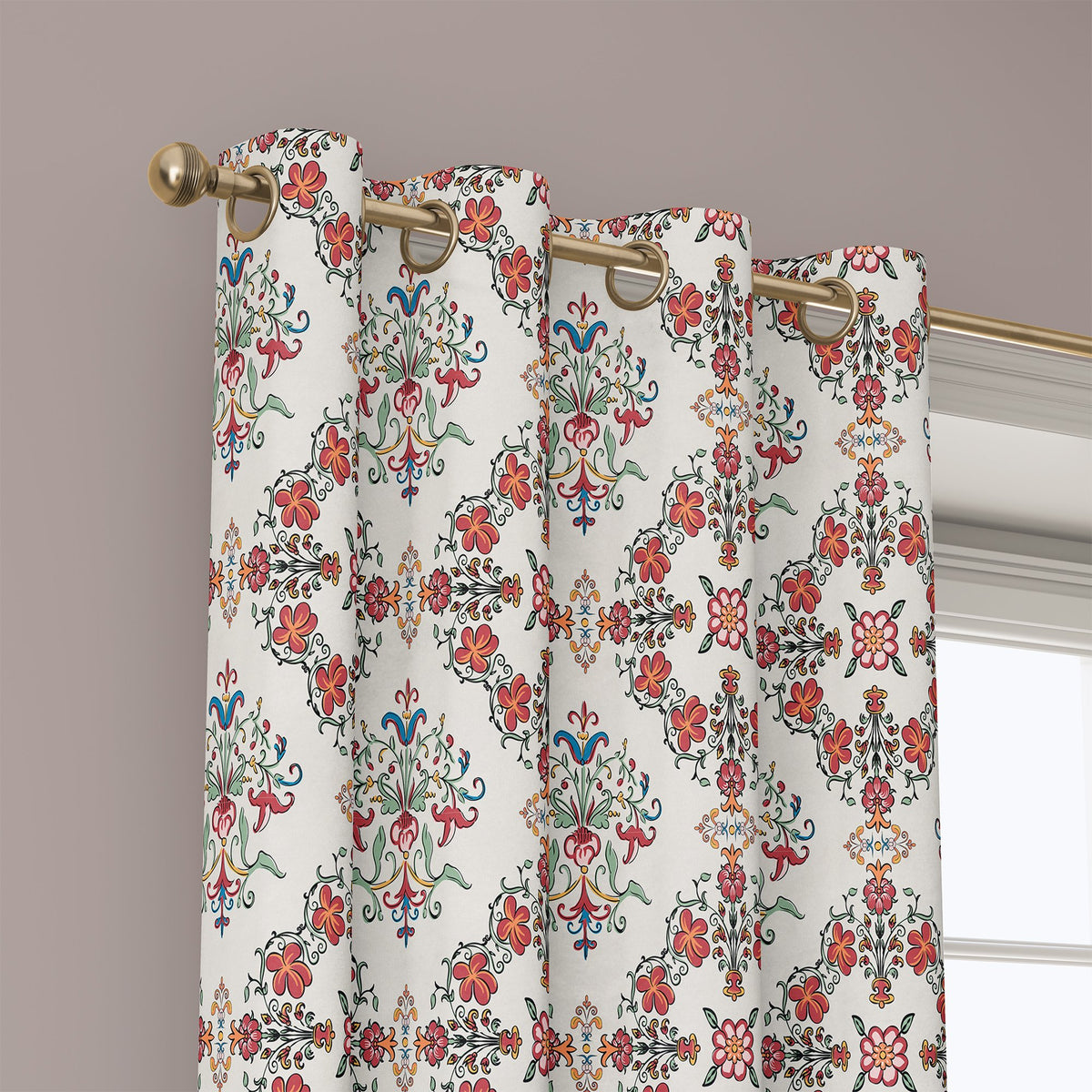 Grommet top of a red medallion tile curtain on a brass rod