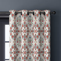 Close-up of red medallion tile curtain grommets on a black rod