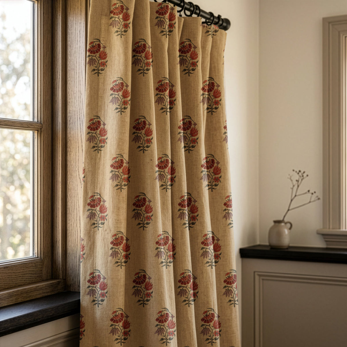 Red poppy block print curtain on a black rod by a window