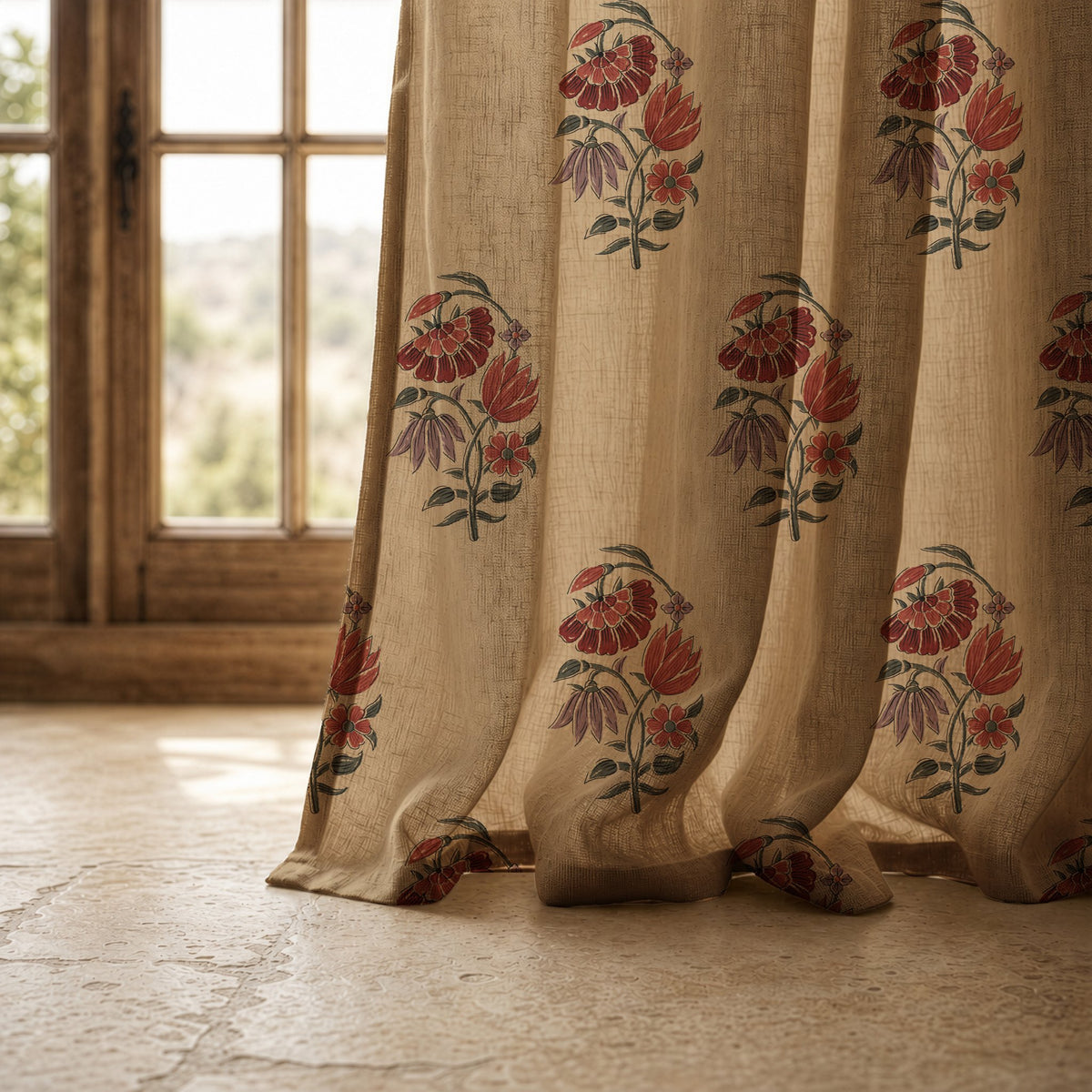 Hem of a red poppy block print curtain resting on a stone floor