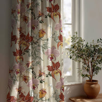 Rust red orchid floral curtain beside a potted olive tree