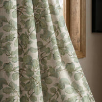 Sage eucalyptus leaf curtain panel beside a rustic wooden window