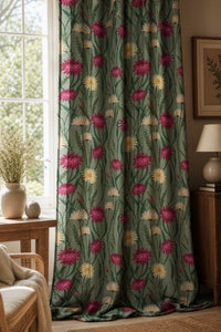 Sage green thistle and daisy curtain on a black rod by a window