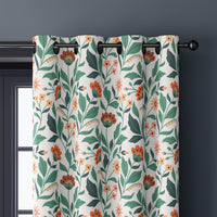 Close-up of teal and coral arts and crafts floral curtain grommets on a black rod