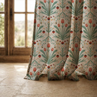 Hem of a teal folk tulip curtain resting on a stone floor