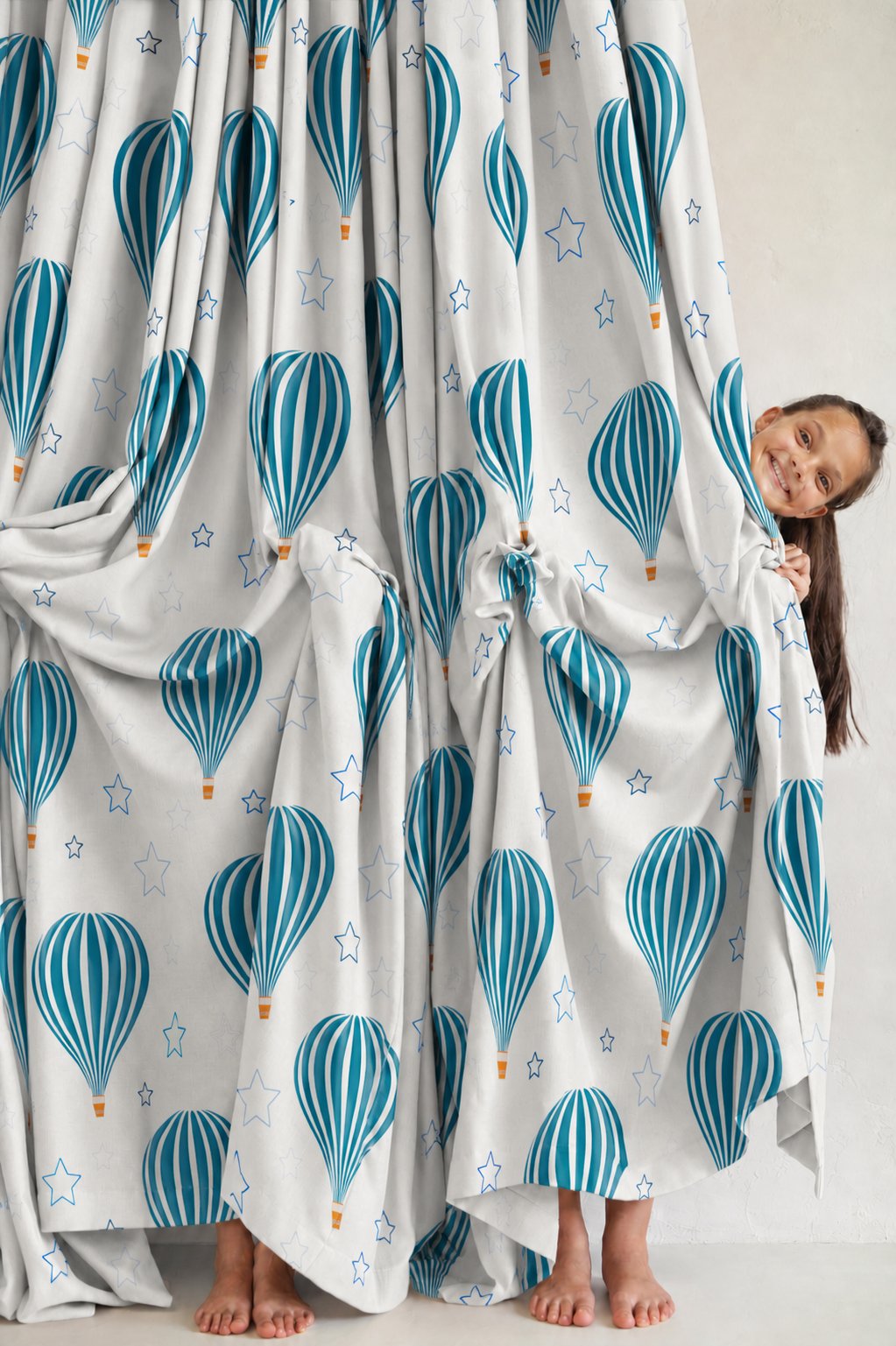 Pair of teal hot air balloon nursery curtains in a child's bedroom