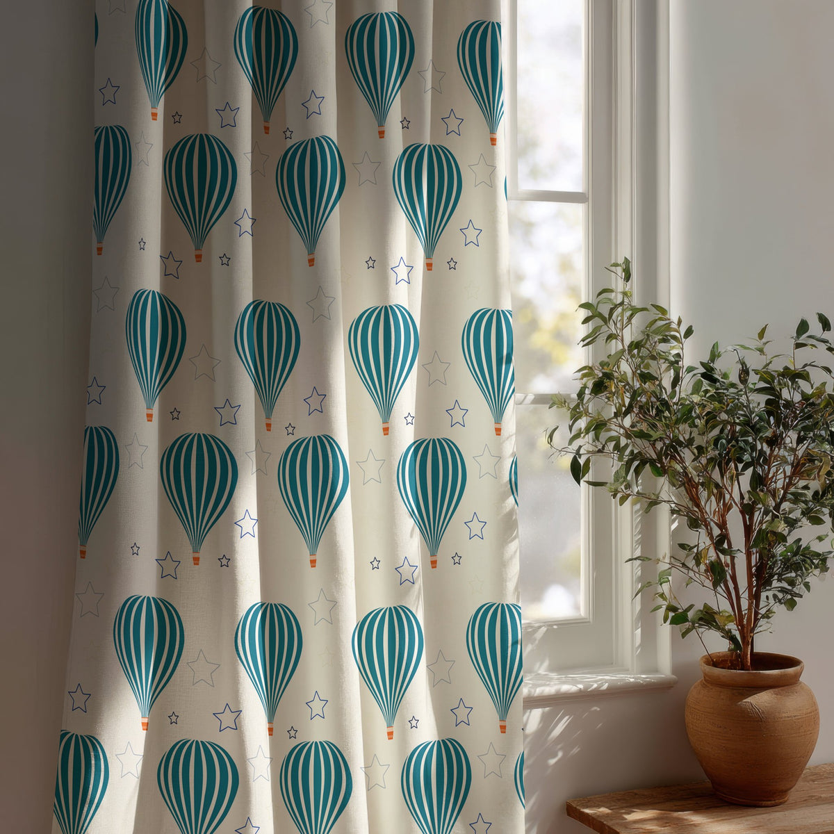 Teal hot air balloon nursery curtain beside a potted olive tree