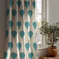 Teal hot air balloon nursery curtain beside a potted olive tree